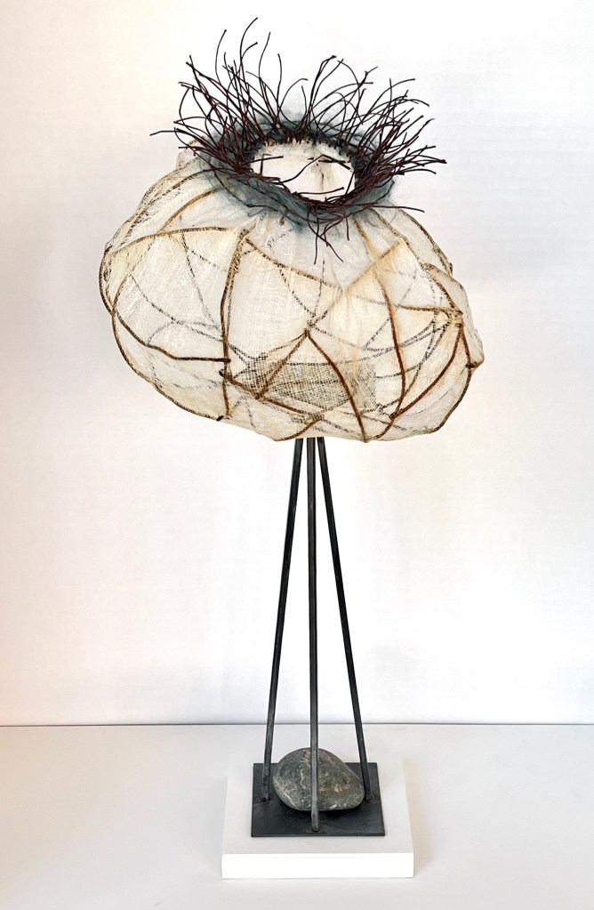 woven wire, cheesecloth, yarn and waxed linen basket on a stand